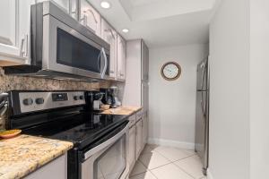 a kitchen with a stove and a microwave at Beach Castle Resort #3 in Longboat Key +27 photos