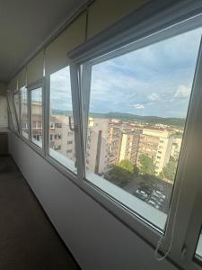 a window in a room with a view of a city at 2 Rooms Center Ramnicu Valcea in Râmnicu Vâlcea