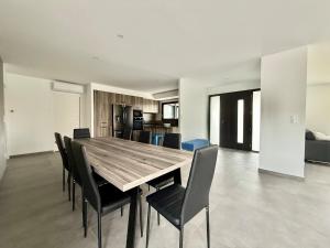 a dining room with a wooden table and chairs at Villa Amara Piscine 7 personnes in Mios