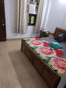 新德里Deepika house的一间卧室,床上放着鲜花