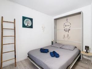 La BuisseL'îlot Cosy, 37m2, 1 terrasse, 1 chambre, 3 pers的一间卧室,配有一张带两个蓝色袋子的床