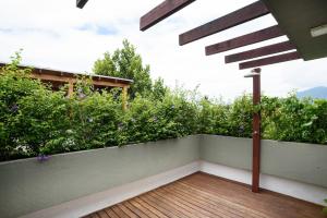 a balcony with a wooden floor and plants at Casa Nova em Maresias in São Sebastião