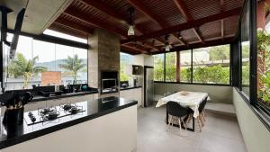 a kitchen with a table and a counter top at Casa Nova em Maresias in São Sebastião