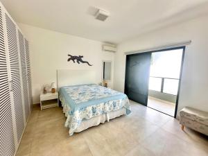 a bedroom with a bed with a blue and white blanket at Casa Nova em Maresias in São Sebastião +19 photos