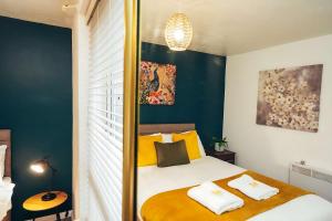 - une chambre avec un lit aux murs jaunes et bleus dans l'établissement Cosy 1-Bed Apartments in Mickleover with Free Parking & WiFi, à Derby