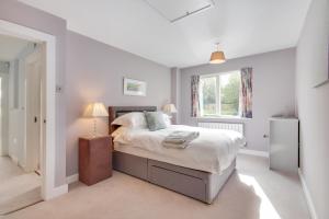a bedroom with a bed and a window at Large Heated Pool with Countryside Views in Cowfold