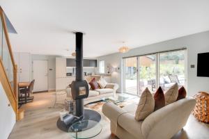 a living room with a wood stove in the middle at Large Heated Pool with Countryside Views in Cowfold