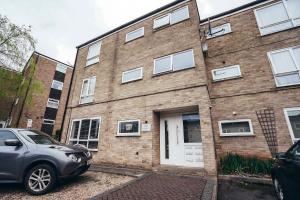 une voiture garée devant un bâtiment en briques dans l'établissement Cosy 1-Bed Apartments in Mickleover with Free Parking & WiFi, à Derby