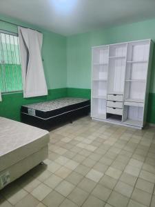 a room with two beds and a green wall at Casa espaçosa e completa para grupos em Salinas in Salinópolis +20 photos