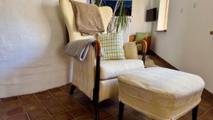 a living room with a chair and a stool at Alte Kate in Hobstin