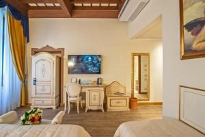 a bedroom with two beds and a table and a chair at Hotel Porta Faenza in Florence