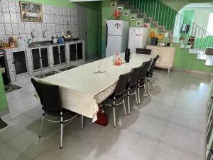a kitchen with a table with chairs and a refrigerator at Casa espaçosa e completa para grupos em Salinas in Salinópolis