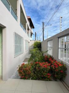 a white building with red flowers on the side of it at Casa espaçosa e completa para grupos em Salinas in Salinópolis