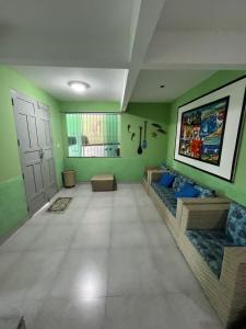 a living room with green walls and a couch at Casa espaçosa e completa para grupos em Salinas in Salinópolis