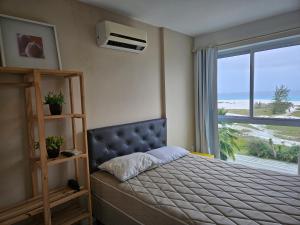 ein Schlafzimmer mit einem Bett mit Blick auf das Meer in der Unterkunft PRAIA DO FORTE - PÉ NA AREIA - 6 hóspedes in Cabo Frio + 19 Fotos