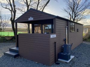 a small shed with a window and stairs at Belraugh Mountain View Hot Tub Lodges in Garvagh
