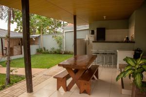 un tavolo in legno e una panca su un patio di Chácara Sabiá a Palmas