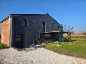 L'entremonts في Steenvoorde: منزل أسود مع درج على جانبه