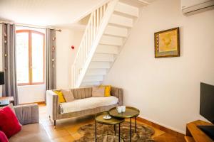 un salon avec un canapé et un escalier dans l'établissement Ferme de Paufy, à Saint-Géry