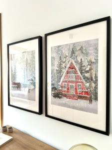 deux tableaux encadrés représentant une grange rouge sur un mur dans l'établissement Apartamento Enseñanza - Barco a Vigo Gratis - Kid Friendly, à Cangas