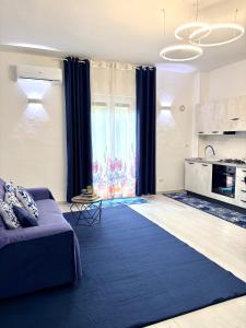 a living room with a couch and a kitchen at Stefy's House in Scalea