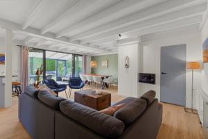 a living room with a couch and a table at Peace and quiet and green near the lake and the sea! 7 people in Ons Belang