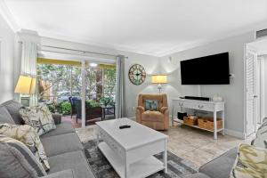 un soggiorno con un divano e una TV di Beach Castle Resort #9 a Longboat Key