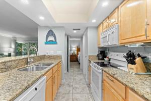 una cucina con armadi in legno e ripiani in marmo di Beach Castle Resort #9 a Longboat Key Altre 22 foto
