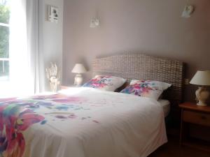 a bedroom with a white bed with flowers on it at Chambres D'hôtes d'Evelyne in Sainte Anne d'Auray 