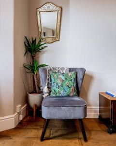 a blue chair with a pillow and a mirror at Sandy Bay - Mins To Margate Main Sands in Margate