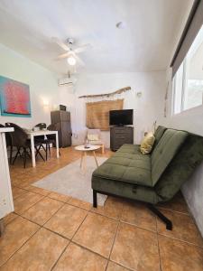 Una sala de estar con un sofá verde y una mesa. en Casita Cártama casa rural jacuzzi, en Estación de Cártama 34 fotos más