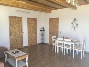 comedor con puertas de madera, mesa y sillas en Anastasia Studios And Suites, en Vrachonisída touArchangélou