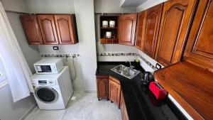 a small kitchen with a washing machine and a sink at Hermoso Departamento Completo en PB in Río Grande