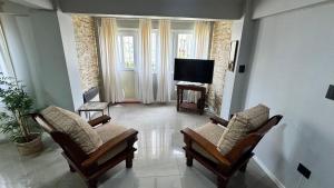 a living room with two chairs and a flat screen tv at Hermoso Departamento Completo en PB in Río Grande