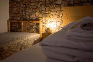 a bedroom with a bed and a stone wall at Casa Elena in Casso