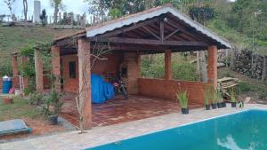 un pabellón junto a una piscina al lado de una casa en condominio recanto dos passaros i, en Jacareí