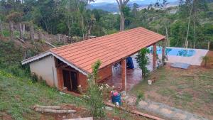 una pequeña casa con techo rojo en una colina en condominio recanto dos passaros i, en Jacareí