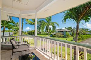 a porch with a chair and palm trees at Princeville/Hanalei Lux 4BR 3.5Ba w/AC+CAR in Princeville