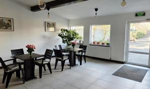 a dining room with two tables and chairs and a window at Confort INN in Otopeni