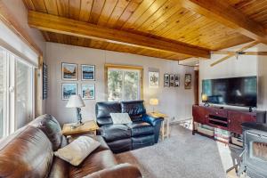 sala de estar con muebles de cuero y TV de pantalla plana en Cle Elum Lake Escape, en Driftwood Acres