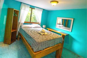 a blue bedroom with a bed with a hat on it at Jodokus Inn in Montezuma