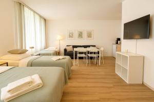 una camera d'albergo con due letti e un tavolo di Airport-Messe Apartments a Dusseldorf