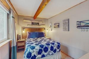 Un dormitorio con una cama azul y blanca y una ventana. en Cle Elum Lake Escape, en Driftwood Acres