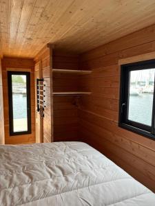 une chambre avec un lit dans une pièce avec une fenêtre dans l'établissement Bateau Lac du Der - Chantecoq - Navigation, 