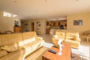 un salon avec deux canapés et une table dans l'établissement Lenerie - 800m plage - Wifi - Parking, à Préfailles