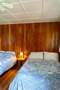 a bedroom with a bed and wooden walls at Jodokus Inn in Montezuma