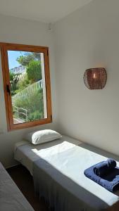 una cama en una habitación con ventana en Apartamento Natalia, en Arenal d'en Castell