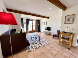 ein Wohnzimmer mit Sofa und Tisch in der Unterkunft Gîte Bijou - Les Petites Écuries in Marseillette