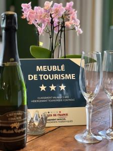 eine Flasche Wein auf einem Tisch mit Brille in der Unterkunft Gîte Bijou - Les Petites Écuries in Marseillette + 6 Fotos