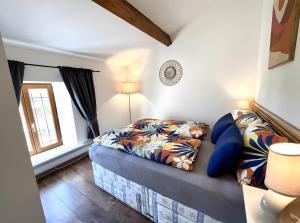 ein Wohnzimmer mit Sofa und Bett in der Unterkunft Gîte Bijou - Les Petites Écuries in Marseillette